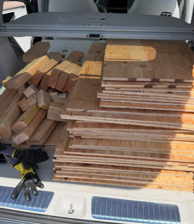 Fresh timber and plywood panels loaded in a car trunk, materials for a Project Archie doghouse build day